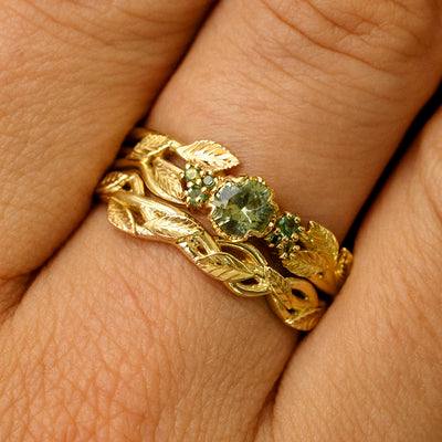A Green Sapphires Leaves and Vines Ring stacked with a Braided Leaves and Vines Ring on a models finger
