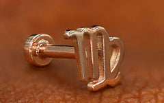 A rose gold Virgo Horoscope Flatback resting on the back of a model's hand