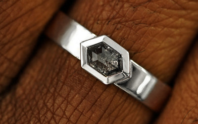 Close up view of a model's fingers wearing a solid white gold Hexagon Diamond Ring
