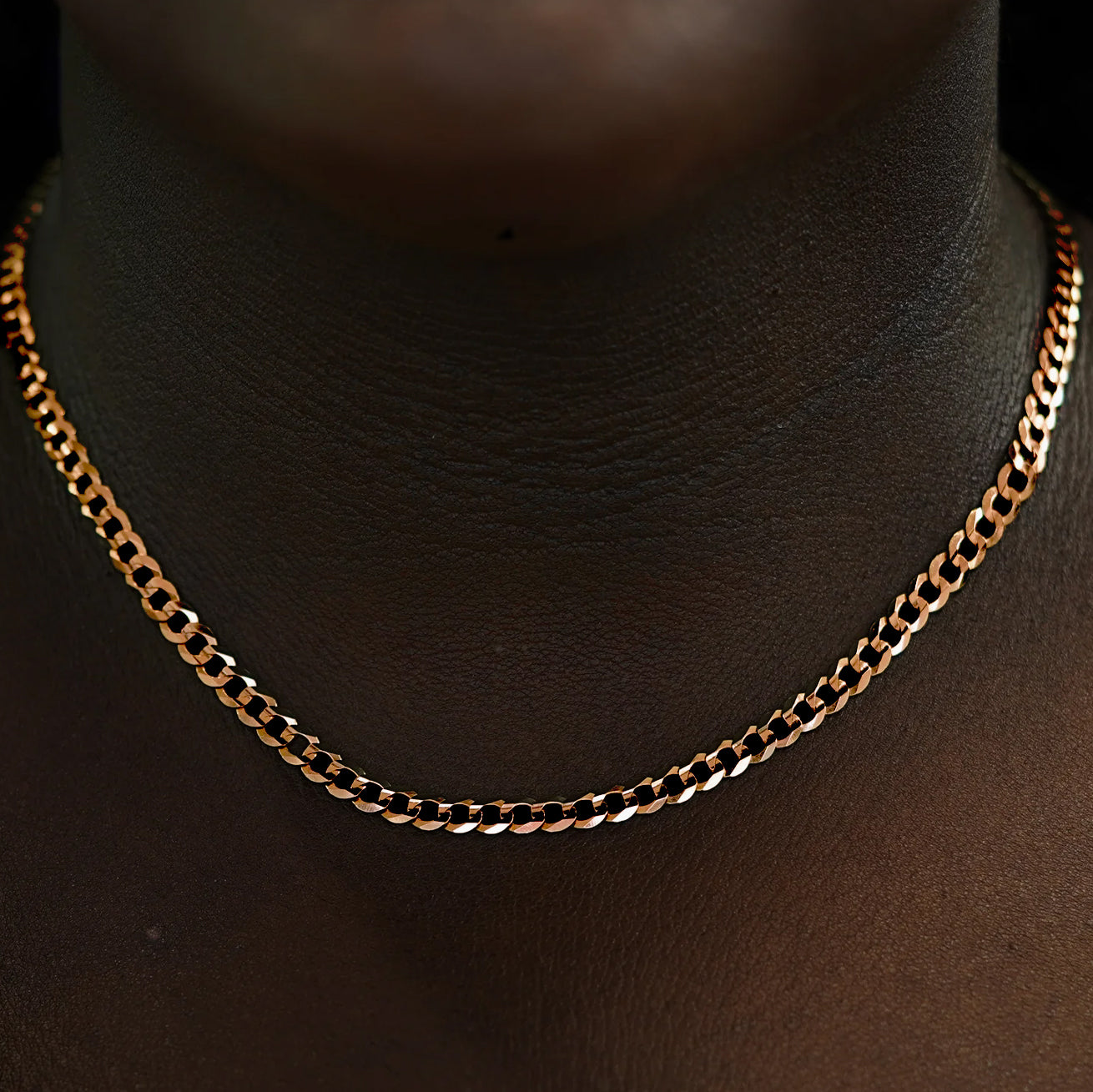 Close up view of a model's neck wearing a solid 14k rose gold Curb Chain