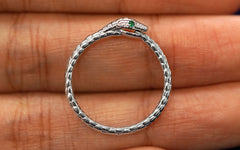 A 14k white gold gemstone Ouroboros Ring with emerald eyes
