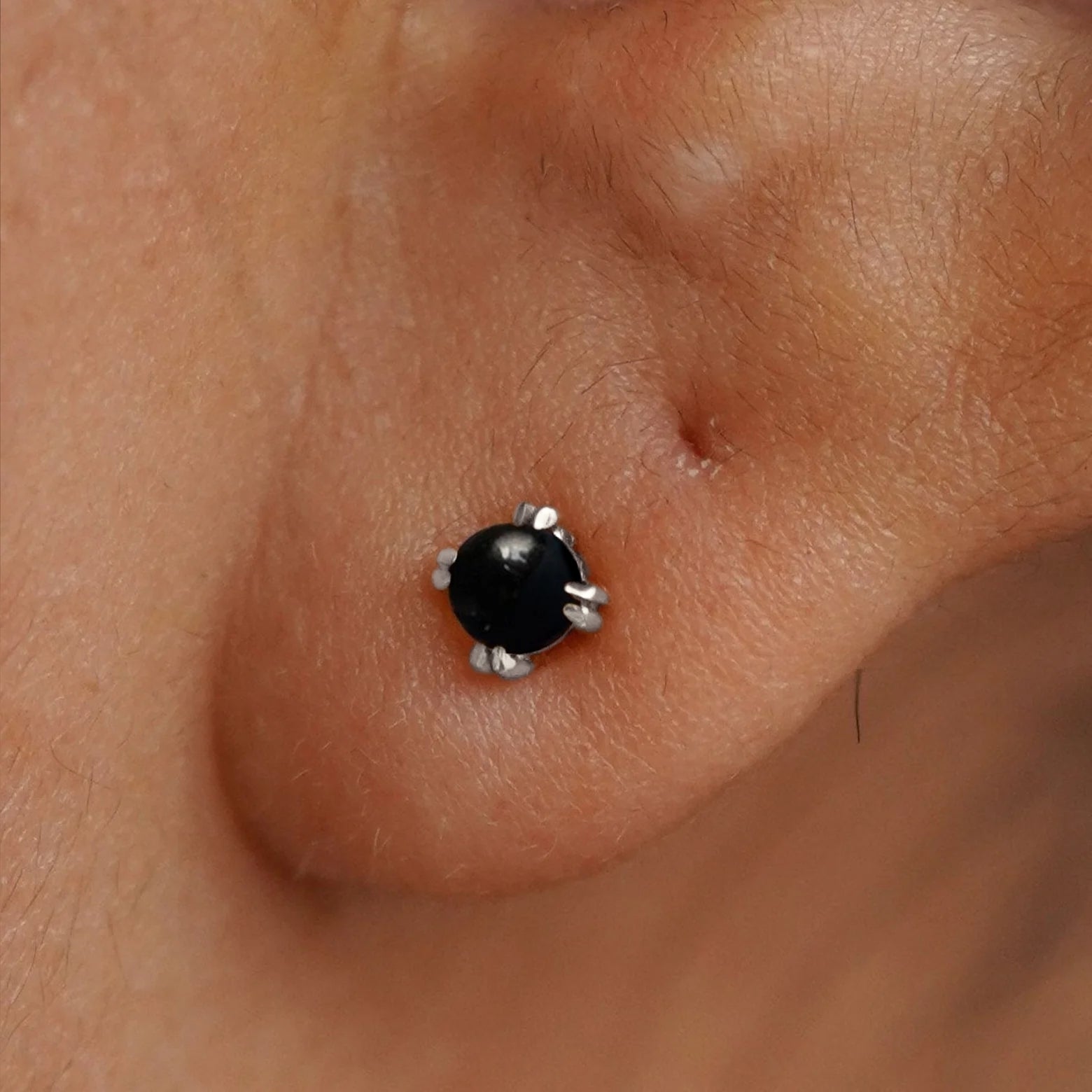 Close up view of a model's ear wearing a 14k white gold Onyx Earring