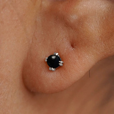 Close up view of a model's ear wearing a 14k white gold Onyx Earring