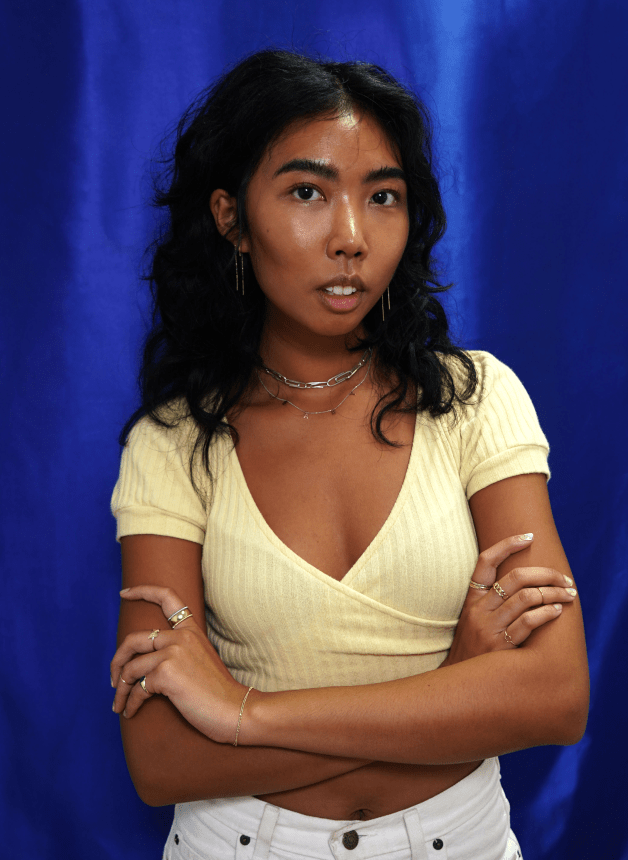 Automic Gold Fashion and Visuals Director Sharena Chindavong posing in front of a dark blue background