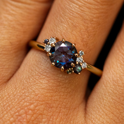 Close up view of a model's fingers wearing a 14k yellow gold Alexandrite Cluster Ring