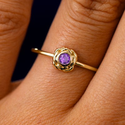 A solid 14k yellow gold Amethyst Gemstone Flower Ring on a model's finger