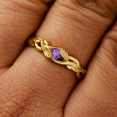 A solid 14k yellow gold amethyst leaves and vines ring on a model's finger