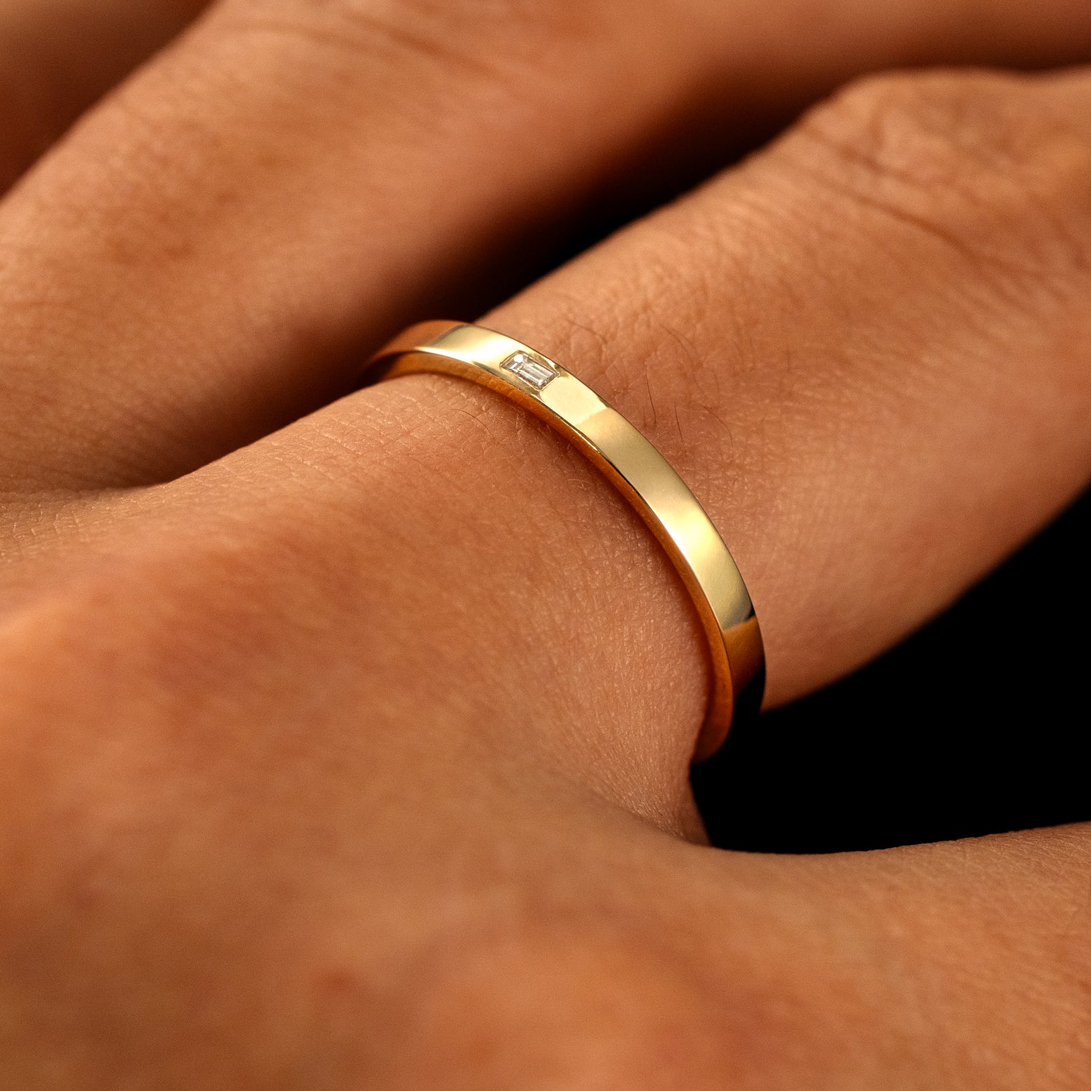 Side view of a Flush Set Baguette Diamond Ring on a model's finger