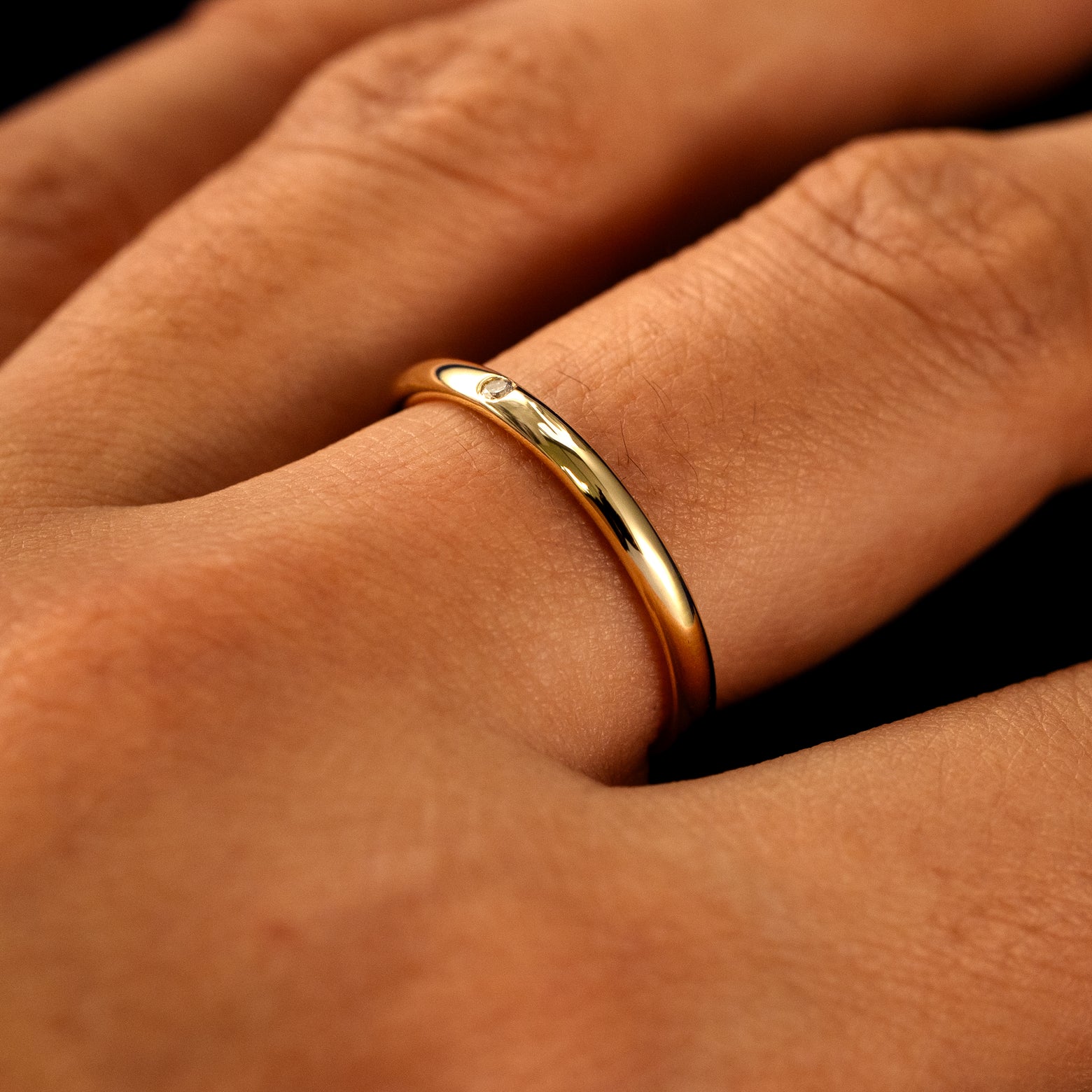 Side view of a Flush Set Round Diamond Ring on a model's finger