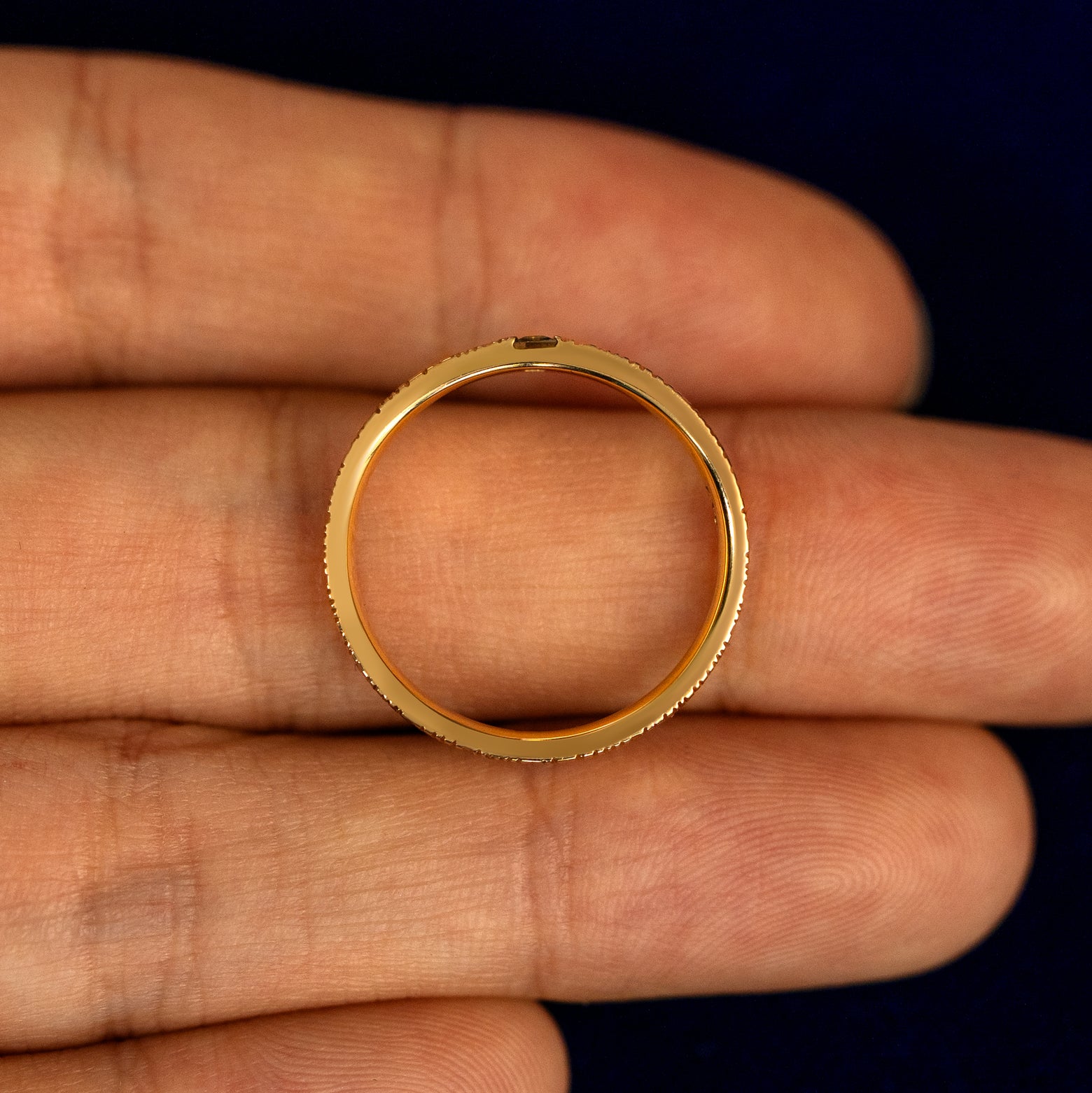 A Baguette Green Sapphire Wood Band lying flat in a models hand to show the thickness of the Ring