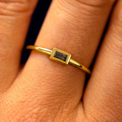Close up view of a model's fingers wearing a 14k yellow gold Baguette Salt and Pepper Diamond Ring