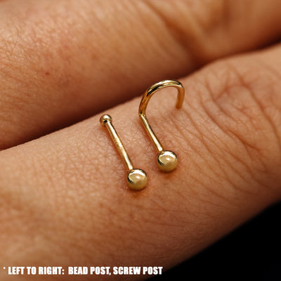 Close up view of a single two Ball Nose Studs with different backings resting on the back on a model's hand