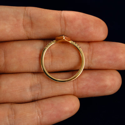 A Kite Salt and Pepper Diamond Pave Chevron Ring in a model's hand showing the thickness of the band