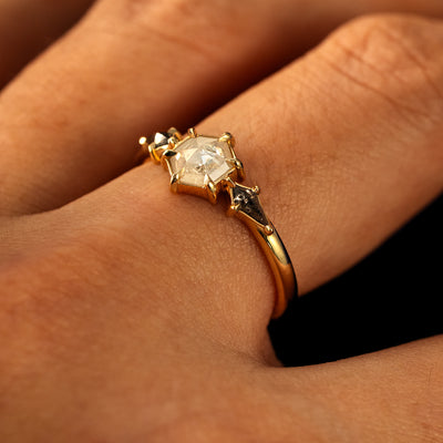 Side view of a solid 14 karat gold Hexagon Salt and Pepper Diamond Black and White Ring on a model's finger