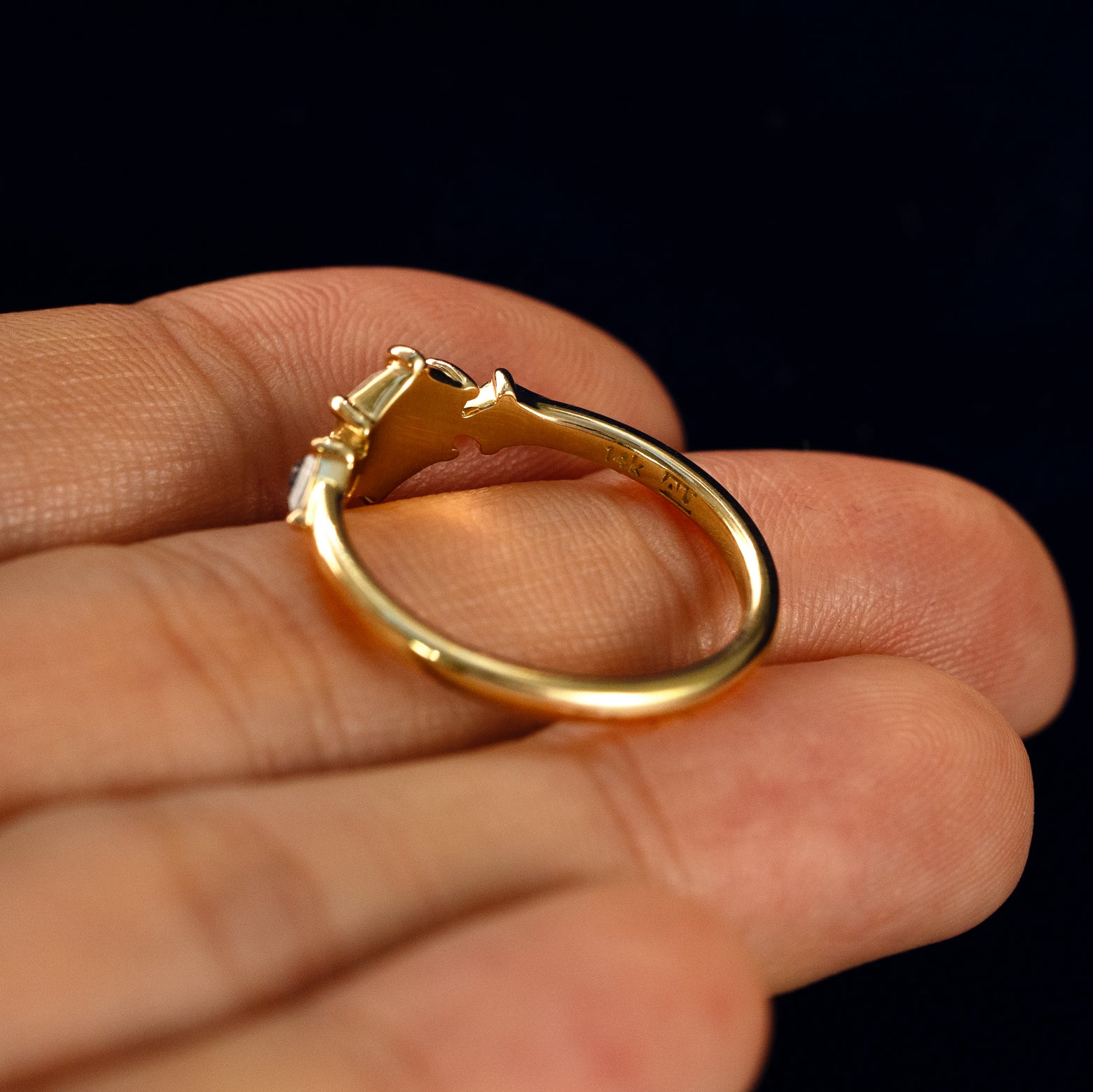 A Hexagon Salt and Pepper Diamond Black and White Ring in a model's hand showing the underside of the stones