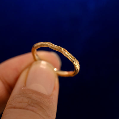 A model holding a Branch Band up to show the details of the design and the inside of the ring
