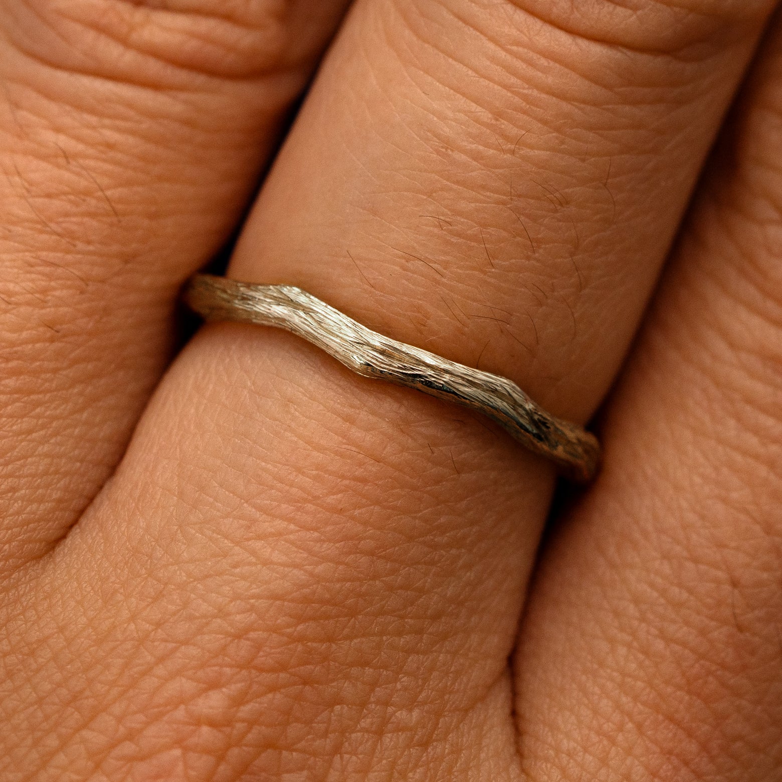 Close up view of a model's fingers wearing a 14k champagne gold Branch Band