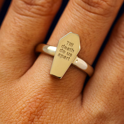 Close up view of a model's hand wearing a champagne gold Coffin Ring in the closed position