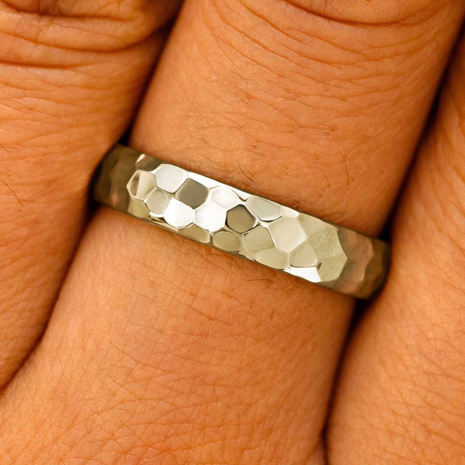 Close up view of a model's fingers wearing a 14k champagne gold Curvy Hammered Band