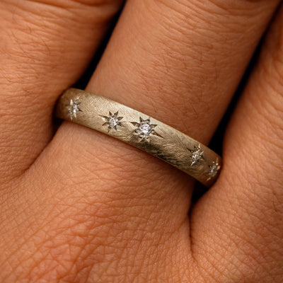 Close up view of a model's fingers wearing a 14k champagne gold Curvy Diamond Stars Velvet Band