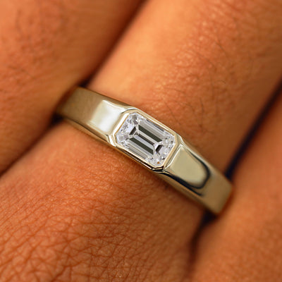 Close up view of a model's fingers wearing a 14k champagne gold Emerald Cut Lab Created Diamond Signet Ring