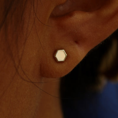 Close up view of a model's ear wearing a champagne gold Hexagon Earring