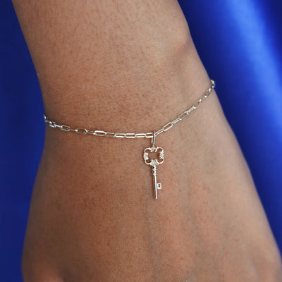 Close up view of a model's wrist wearing a rose gold Key Charm on a Butch Bracelet