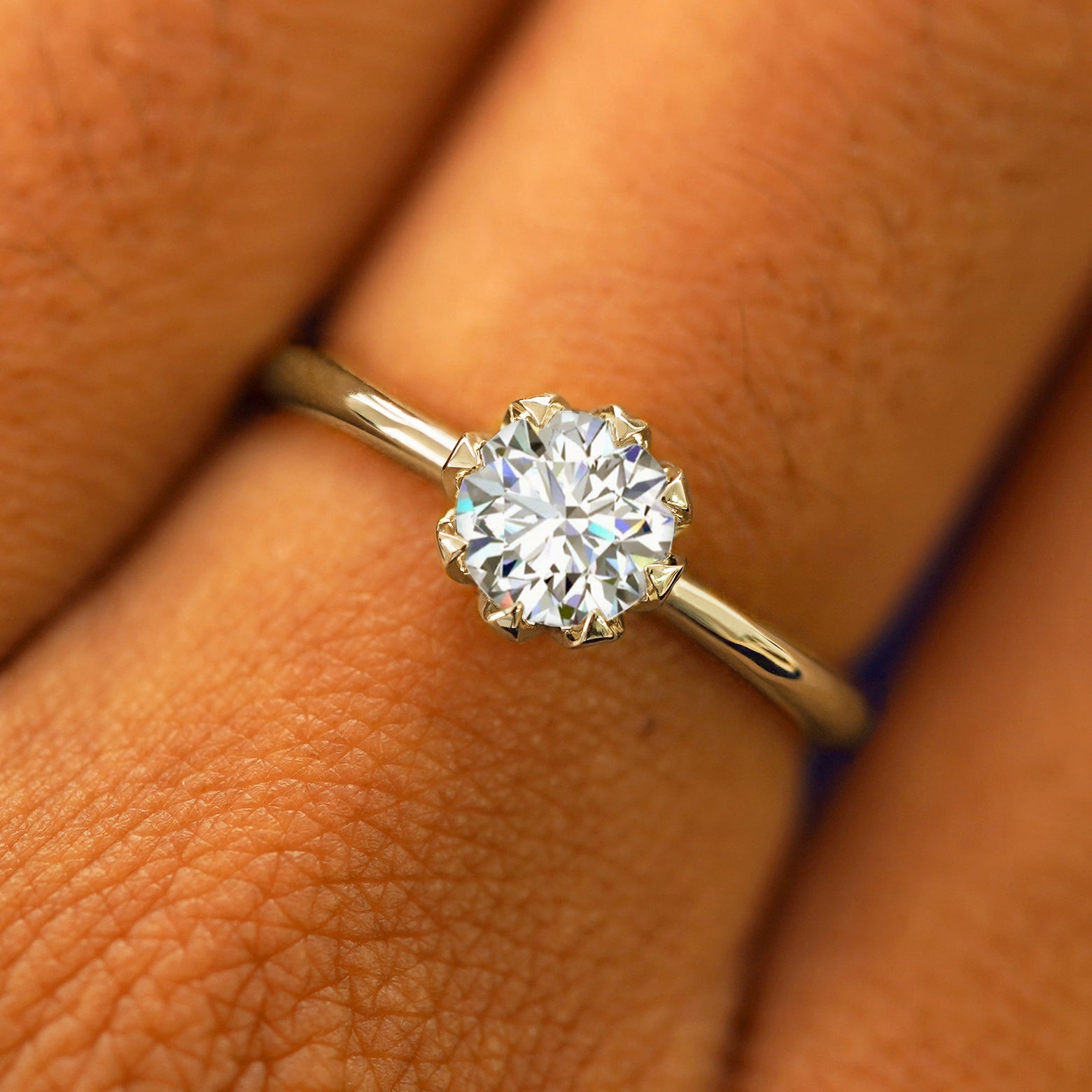 Close up view of a model's hand wearing a solid champagne gold Lab Diamond Petal Ring