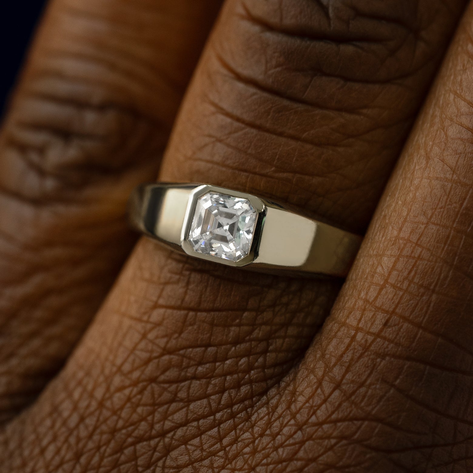 Close up view of a models hand wearing a 14k champagne gold asscher lab gemstone ring