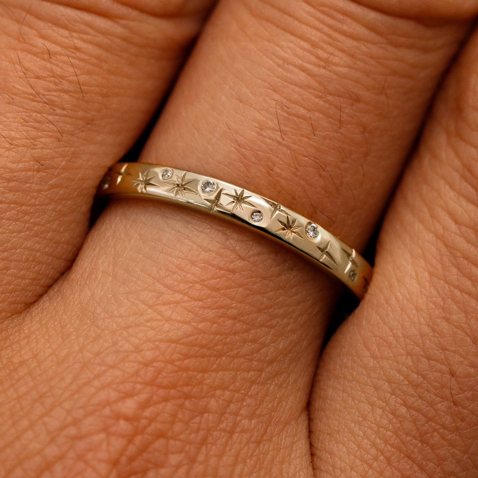 Close up view of a model's fingers wearing a 14k champagne gold Mixed Diamond Stars Band