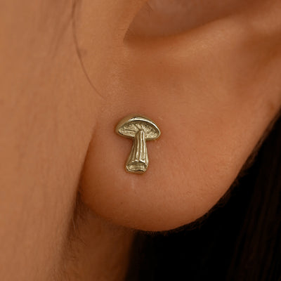 Close up view of a model's ear wearing a 14k champagne gold Mushroom Earring