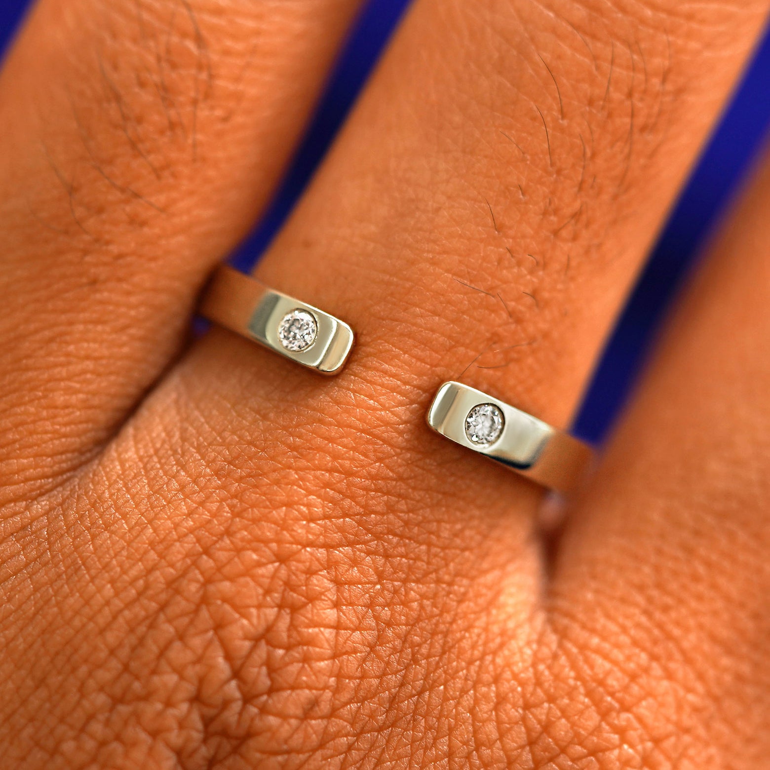 Close up view of a model's fingers wearing a 14k champagne gold Open Industrial Band