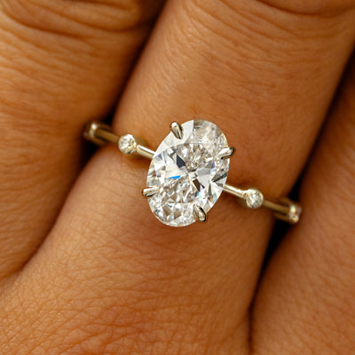 A solid 14k champagne gold Oval Lab Diamond Bubble Ring on a model's finger