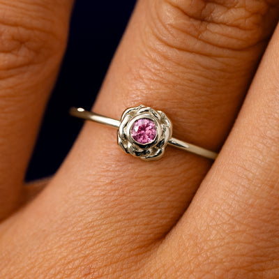 A solid 14k champagne gold Pink Sapphire Gemstone Flower Ring on a model's finger