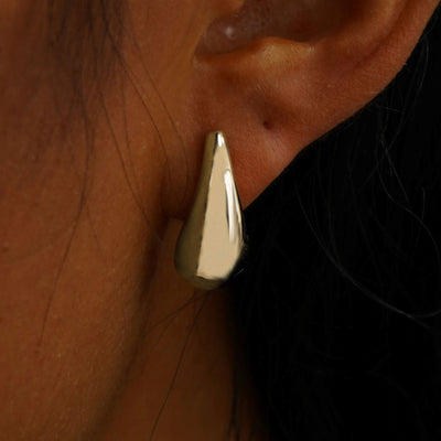 Close up view of a model's ear wearing a champagne gold black 5mm Moissanite Earring