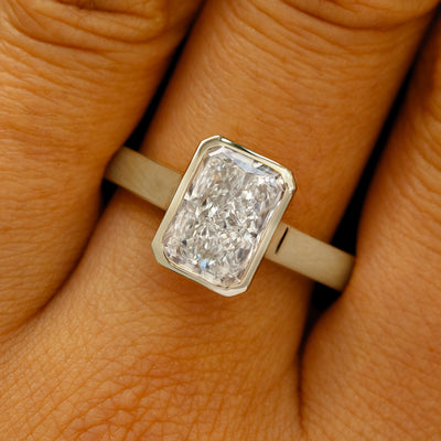 A solid 14k champagne gold Radiant Cut Lab Diamond Cathedral Ring on a model's finger