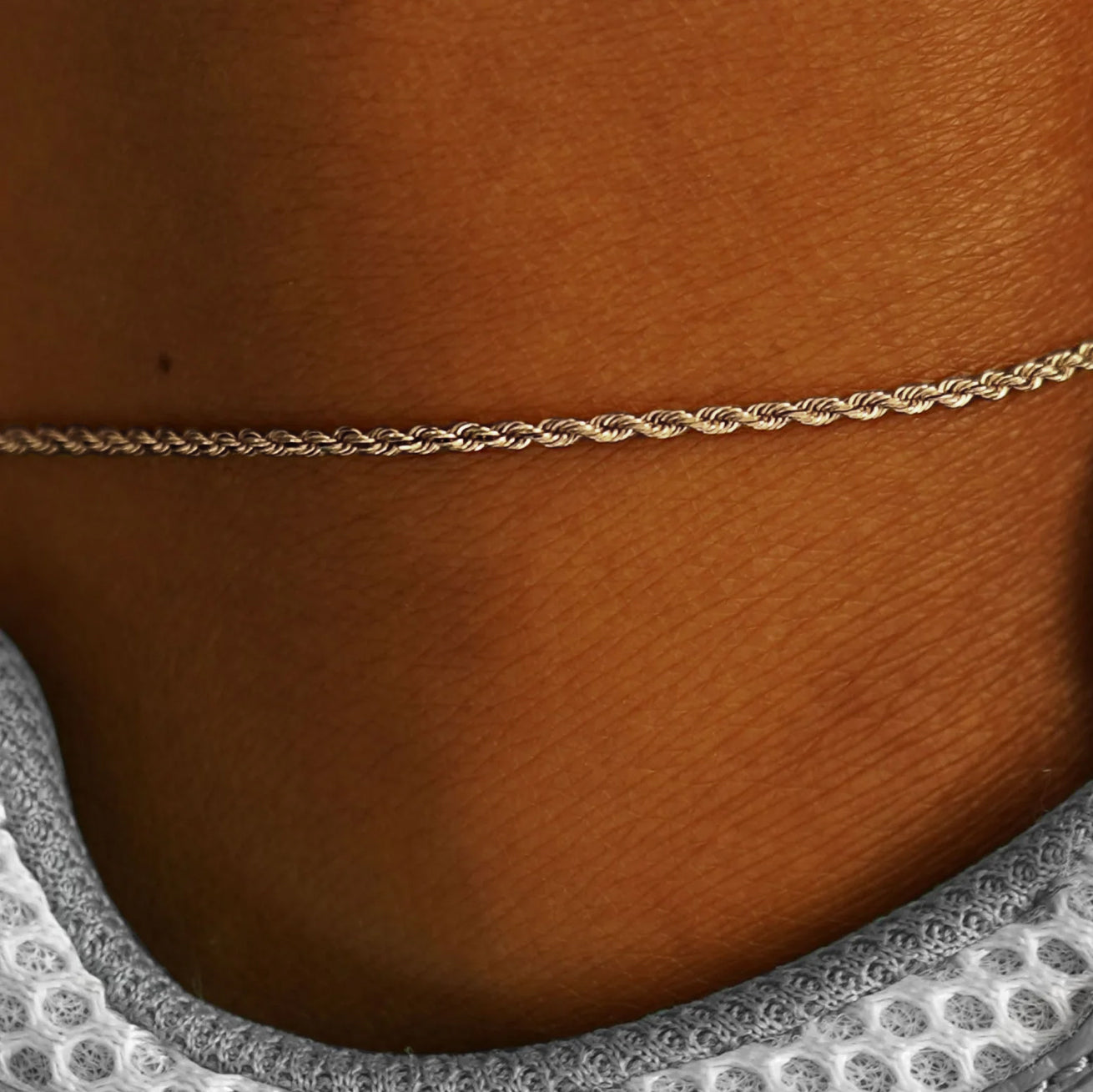 Close up view of a model's ankle wearing a champagne gold Rope Anklet