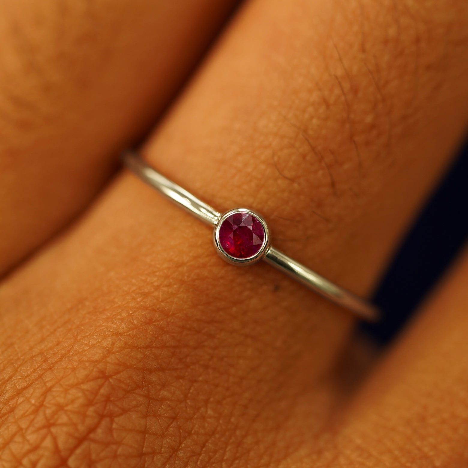 Close up view of a model's hand wearing a champagne gold Ruby Ring