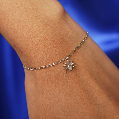 Close up view of a model's wrist wearing a champagne gold Spider Charm on a Butch Chain Bracelet
