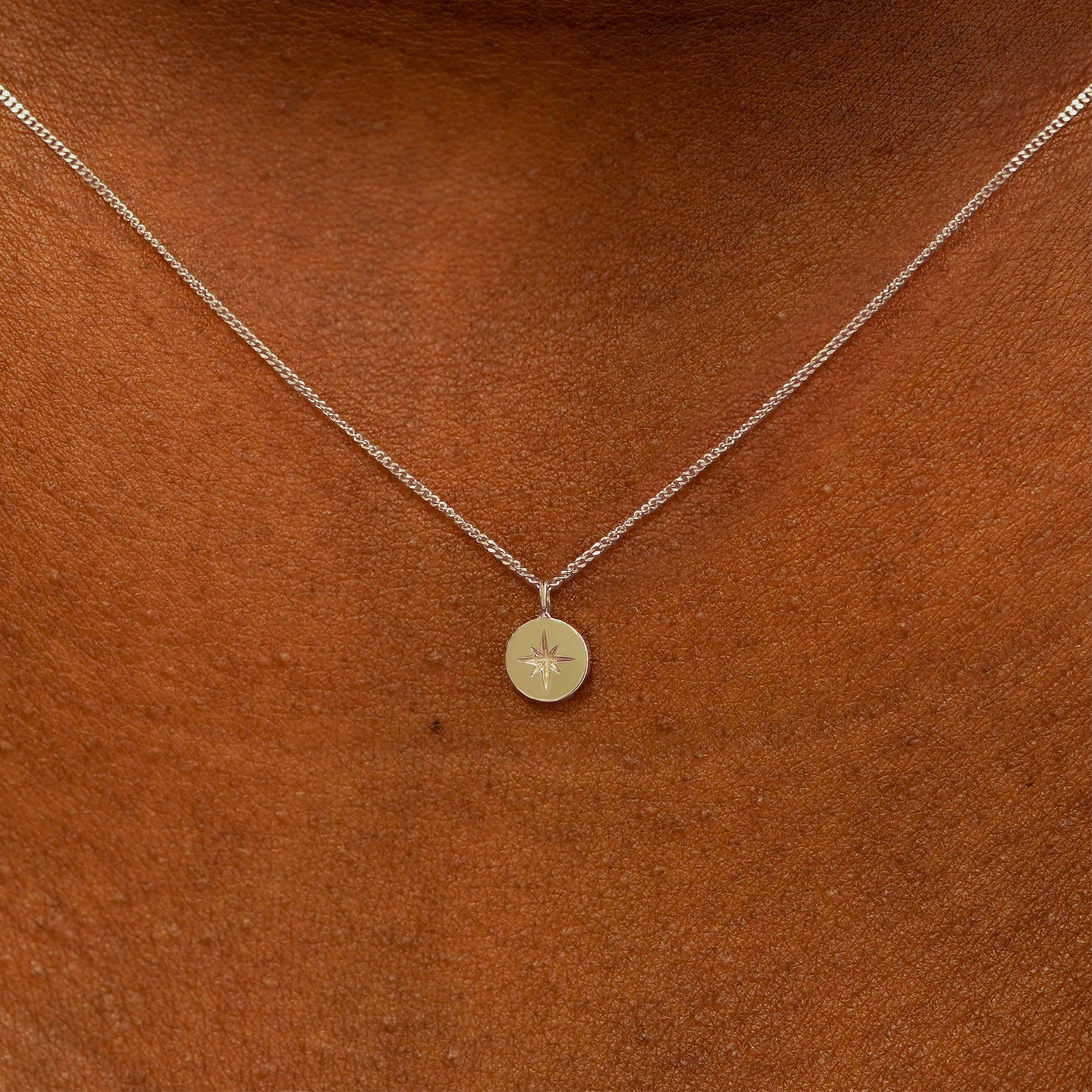 Close up view of a model's neck wearing a 14k champagne gold Star Disk Necklace