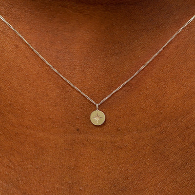 Close up view of a model's neck wearing a 14k champagne gold Star Disk Necklace