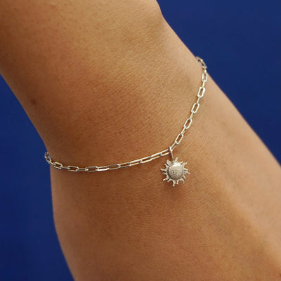 Close up view of a model's wrist wearing a champagne gold Sun Charm on a Butch Chain Bracelet