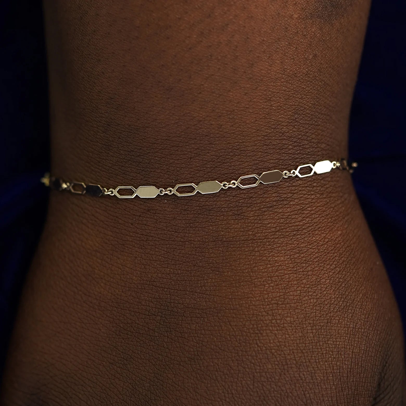 A model's wrist wearing a solid champagne gold Tanlah Bracelet
