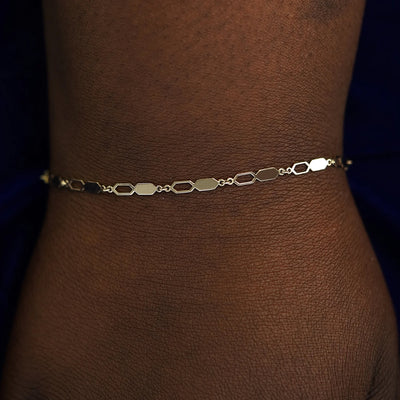 A model's wrist wearing a solid champagne gold Tanlah Bracelet