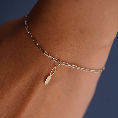 Close up view of a model's wrist wearing a champagne gold Tanlah Charm on a Butch Bracelet
