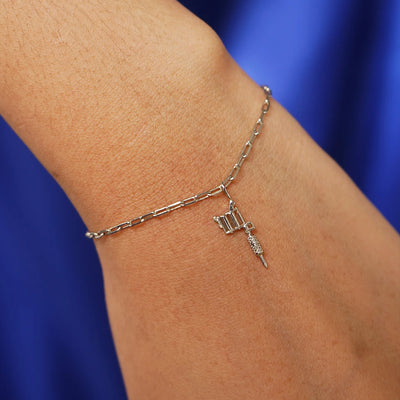 Close up view of a model's wrist wearing a champagne gold Tattoo Machine Charm on a Butch Bracelet