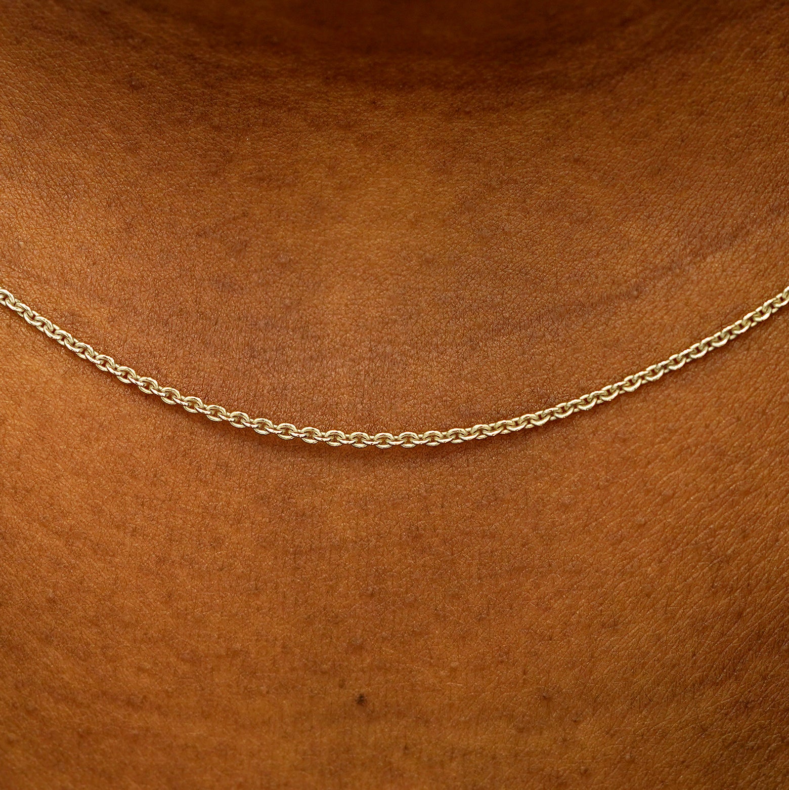 Close up view of a model's neck wearing a solid 14k champagne gold Thick Cable Chain
