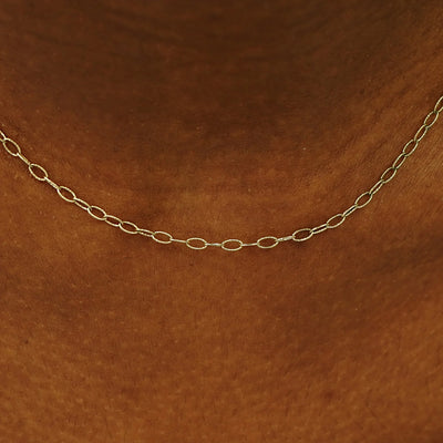Close up view of a model's neck wearing a solid champagne gold Veren Chain
