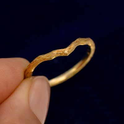 A model holding a Chevron Branches Band up to show the details of the chevron design and the inside of the ring