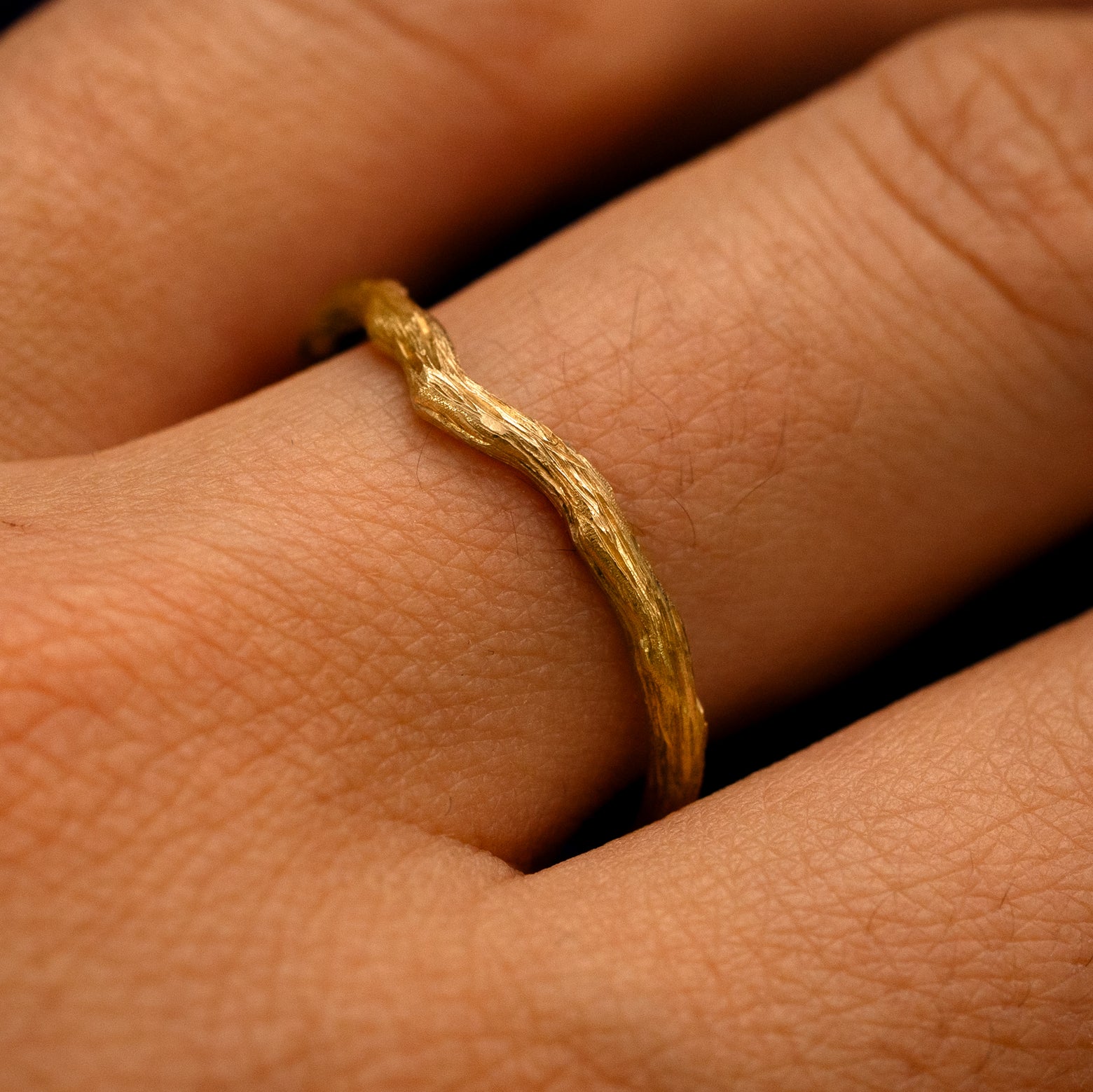 Side view of a Chevron Branches Band on a model's finger